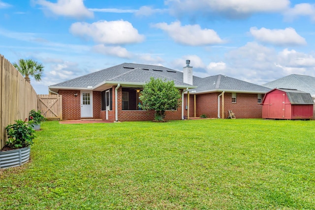 back of house featuring a storage unit and a lawn