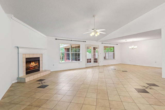 unfurnished living room with crown molding, a tile fireplace, light tile floors, and ceiling fan with notable chandelier