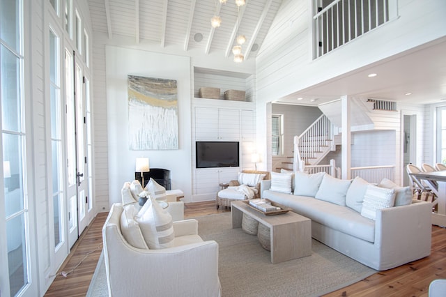 living room with wood ceiling, hardwood / wood-style floors, high vaulted ceiling, and a wealth of natural light