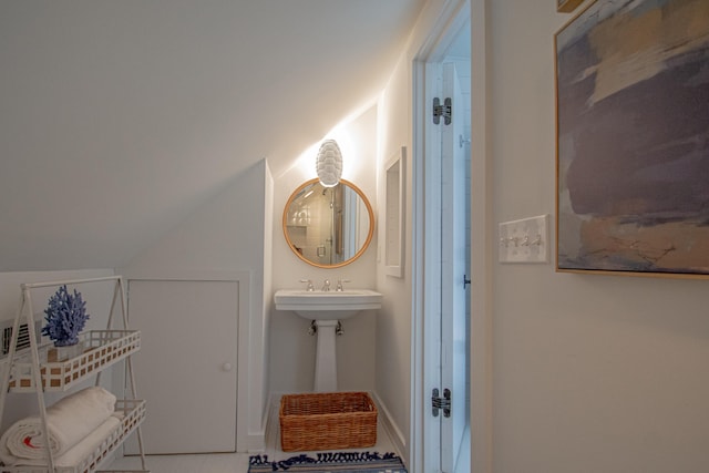 bathroom featuring lofted ceiling and tile patterned flooring