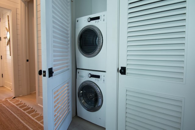 clothes washing area with stacked washer and clothes dryer