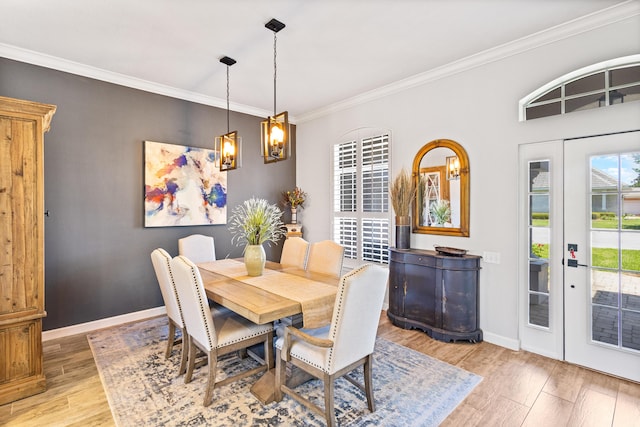 dining area featuring a chandelier, light hardwood / wood-style floors, crown molding, and a healthy amount of sunlight