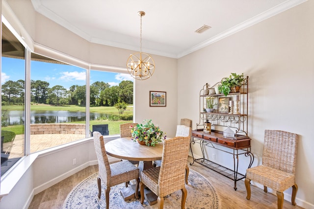 dining area featuring hardwood / wood-style floors, a water view, crown molding, and a notable chandelier