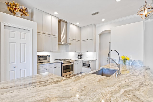 kitchen featuring stainless steel range, white cabinets, and sink