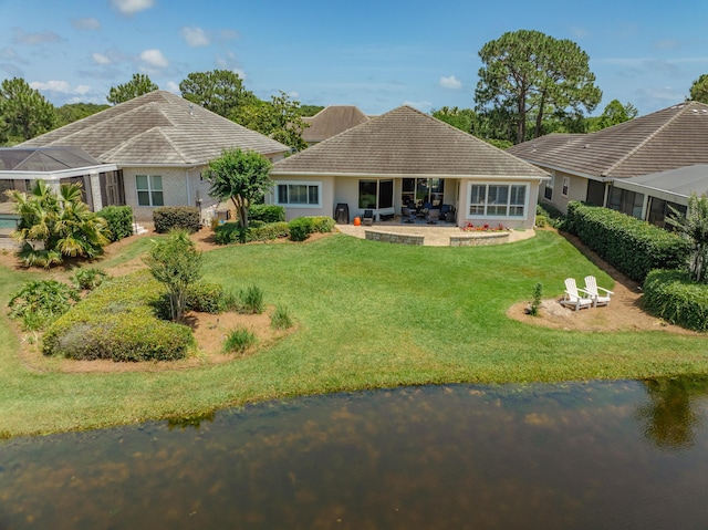 back of house with a patio area, a yard, and a water view