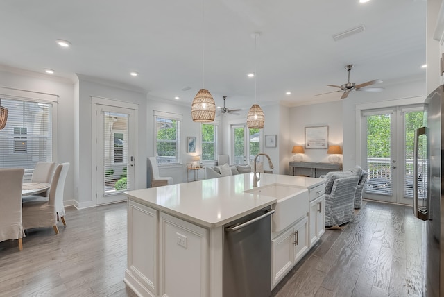 kitchen with appliances with stainless steel finishes, white cabinetry, an island with sink, and ceiling fan