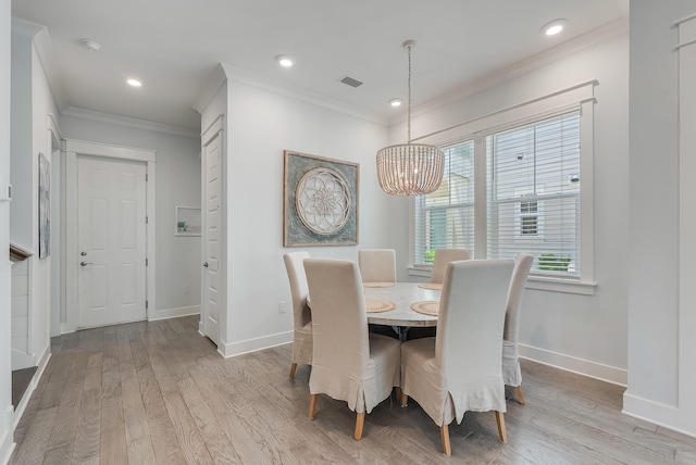 dining area featuring a chandelier, light wood-type flooring, and crown molding