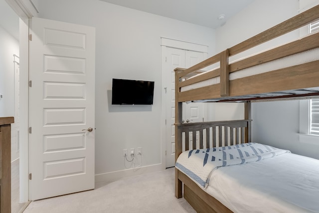 bedroom featuring light colored carpet and a closet