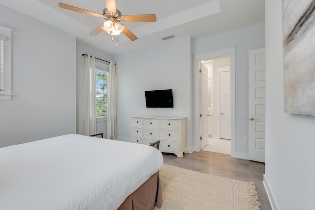 tiled bedroom featuring connected bathroom and ceiling fan