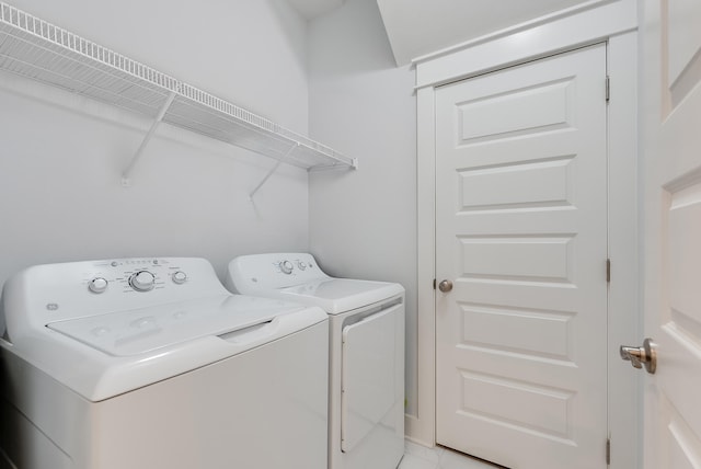 laundry area featuring separate washer and dryer and light tile floors