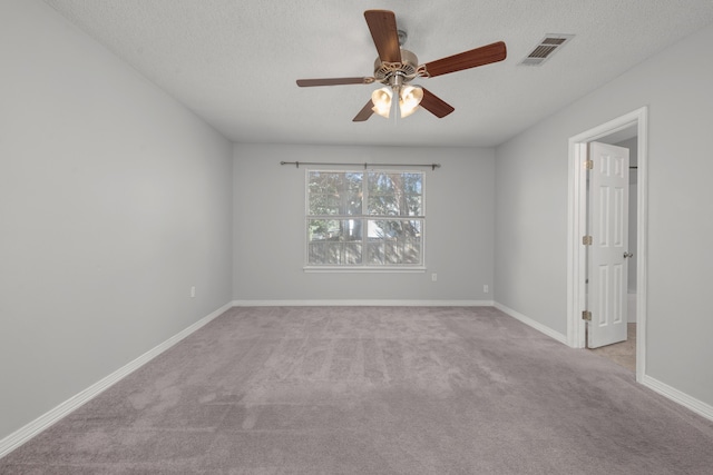 carpeted spare room with ceiling fan and a textured ceiling