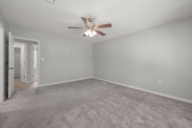 spare room with light carpet, ceiling fan, and a textured ceiling