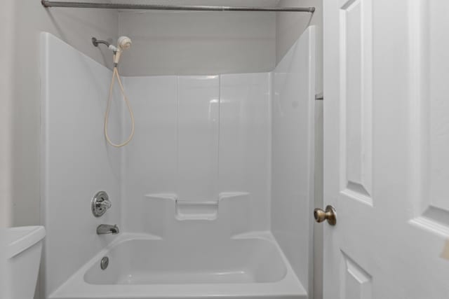 bathroom featuring toilet and shower / washtub combination