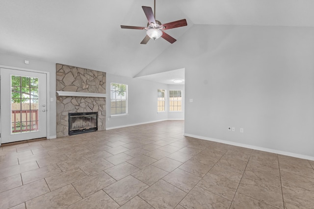 unfurnished living room with a fireplace, high vaulted ceiling, a wealth of natural light, and ceiling fan