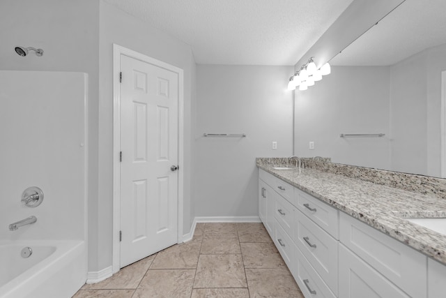 bathroom with vanity, bathtub / shower combination, a textured ceiling, and tile patterned floors