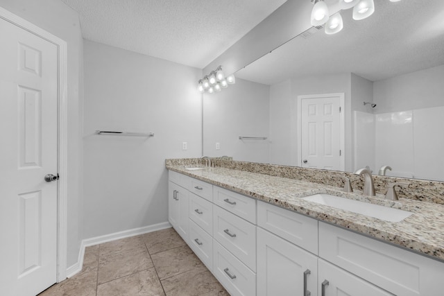 bathroom featuring tile patterned floors, vanity, and a textured ceiling