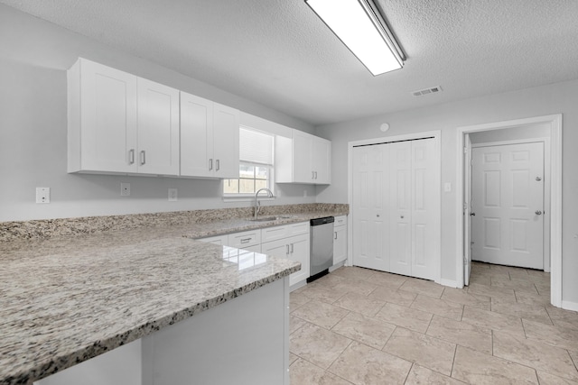 kitchen featuring white cabinets, light stone counters, a textured ceiling, sink, and dishwasher