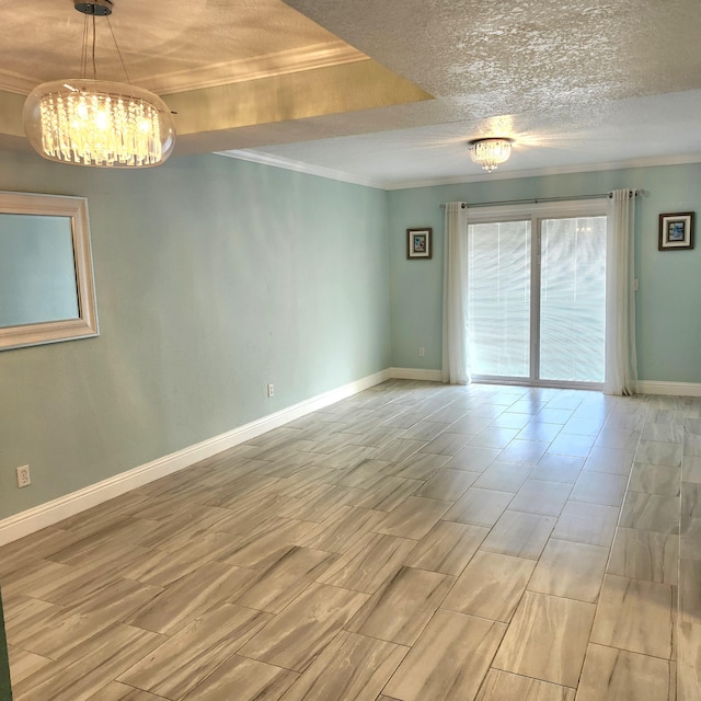 unfurnished room featuring a tray ceiling, a textured ceiling, and ornamental molding