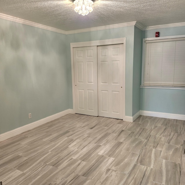 unfurnished bedroom with a textured ceiling, a closet, and ornamental molding