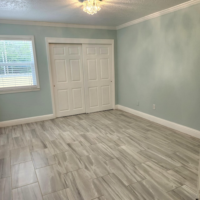 unfurnished bedroom with ornamental molding, a textured ceiling, and a closet