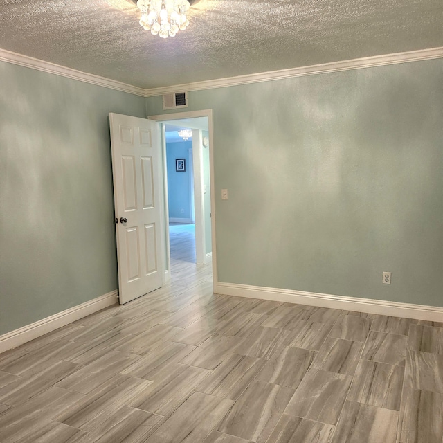 unfurnished room with a textured ceiling and ornamental molding