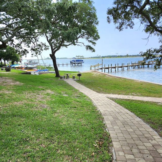 view of dock featuring a water view and a yard