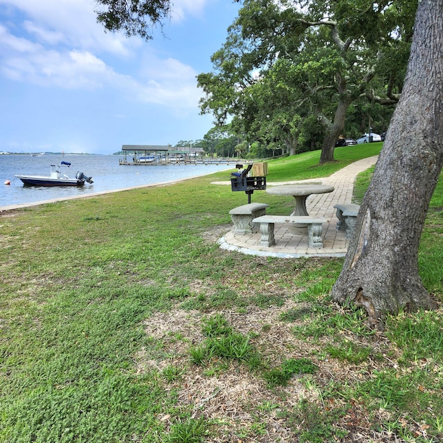 view of community featuring a water view and a lawn