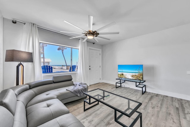 living room featuring wood finished floors, baseboards, and a ceiling fan