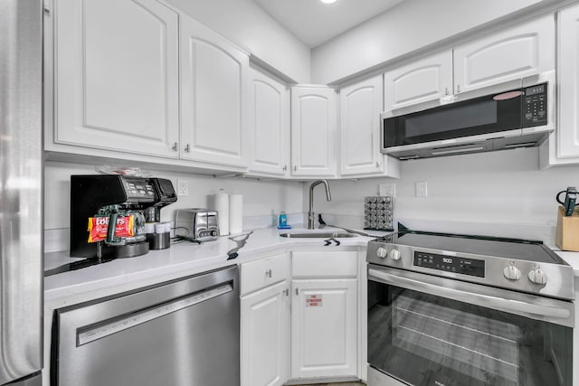 kitchen with light countertops, a sink, white cabinetry, and stainless steel appliances