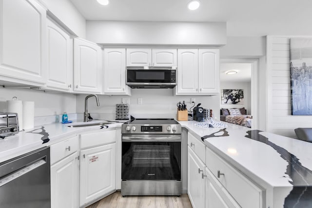 kitchen with light countertops, a sink, white cabinetry, and stainless steel appliances