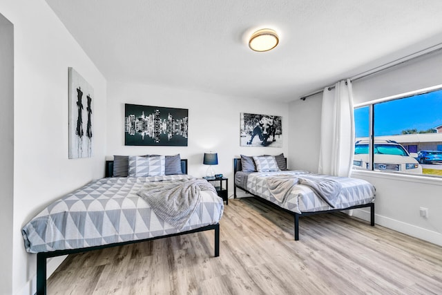 bedroom featuring wood finished floors and baseboards