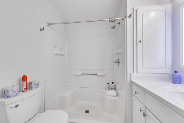 bathroom with toilet, vanity, and a shower
