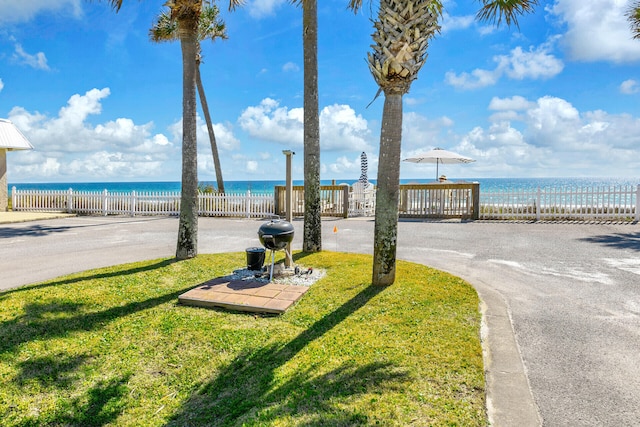 exterior space with a yard, fence, and a water view
