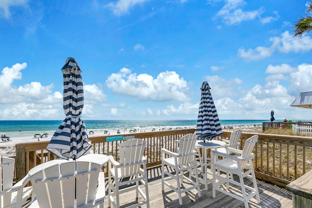 wooden deck with a view of the beach and a water view