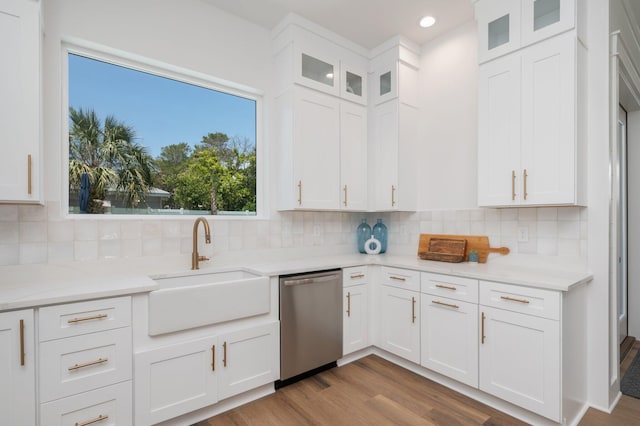 kitchen featuring tasteful backsplash, white cabinetry, dishwasher, and light wood-type flooring