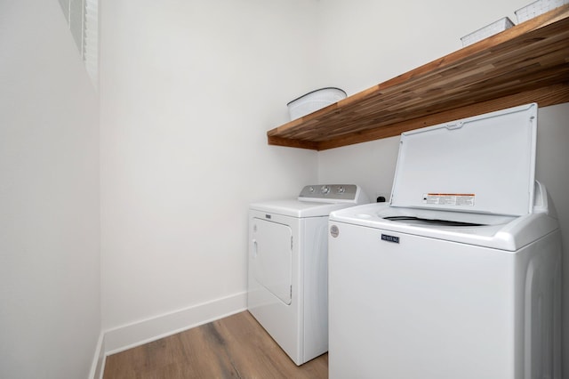 washroom with light hardwood / wood-style floors and washer and clothes dryer