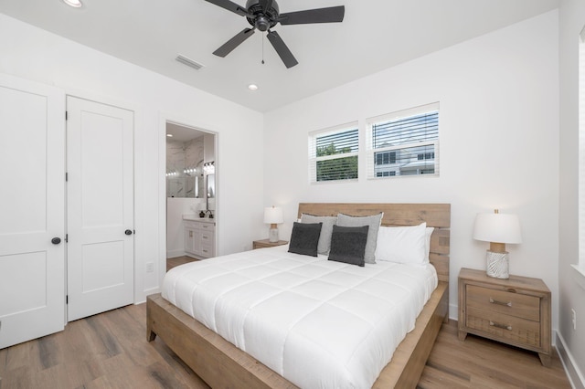 bedroom with connected bathroom, ceiling fan, and wood-type flooring