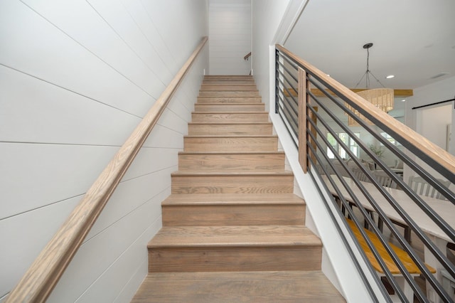 staircase featuring wood walls