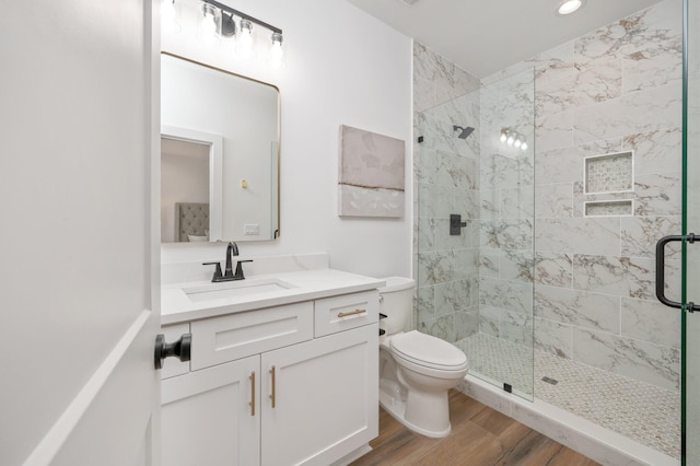 bathroom featuring hardwood / wood-style flooring, vanity, toilet, and walk in shower