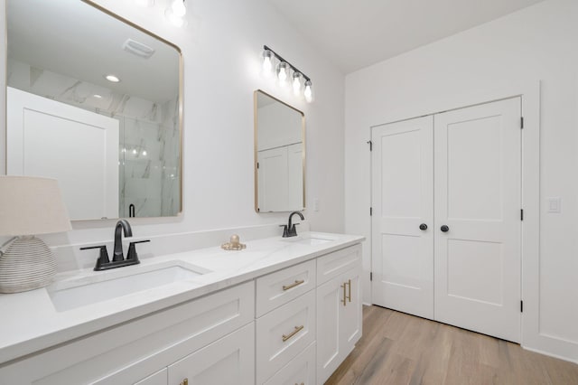 bathroom featuring hardwood / wood-style floors, vanity, and a shower with door