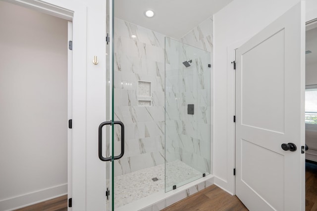 bathroom with hardwood / wood-style flooring and an enclosed shower