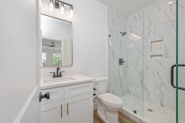 bathroom featuring ceiling fan, toilet, a shower with door, vanity, and hardwood / wood-style flooring