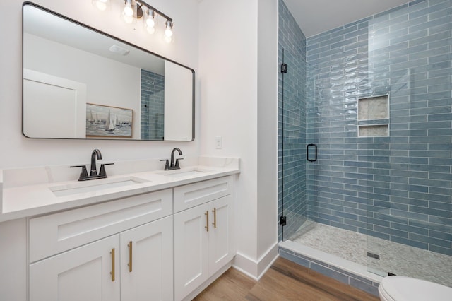 bathroom featuring hardwood / wood-style floors, vanity, toilet, and walk in shower