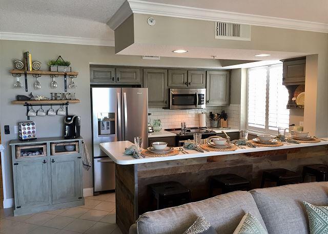 kitchen with appliances with stainless steel finishes, ornamental molding, and tasteful backsplash