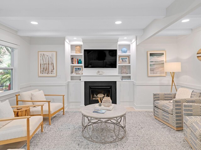 living room featuring built in shelves and beamed ceiling