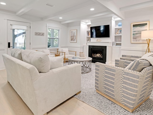 living room with beam ceiling, light wood-type flooring, and built in features