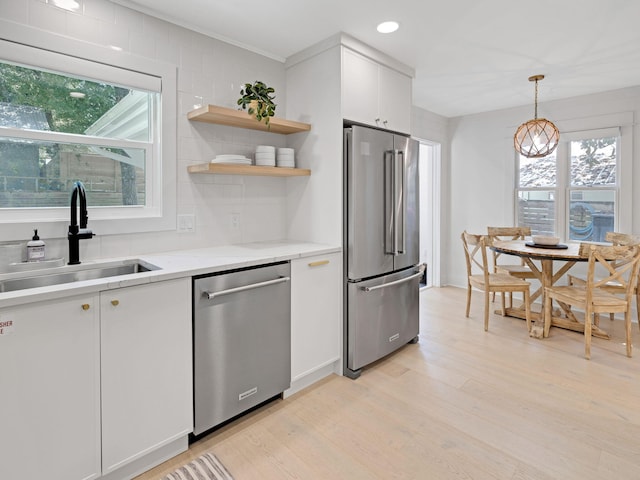 kitchen with white cabinets, plenty of natural light, sink, and appliances with stainless steel finishes