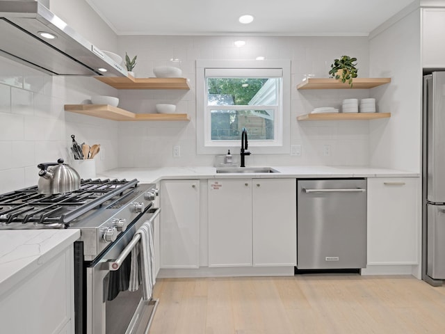 kitchen featuring white cabinets, sink, decorative backsplash, light stone counters, and stainless steel appliances