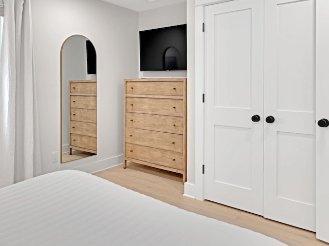 bedroom with hardwood / wood-style flooring and a closet