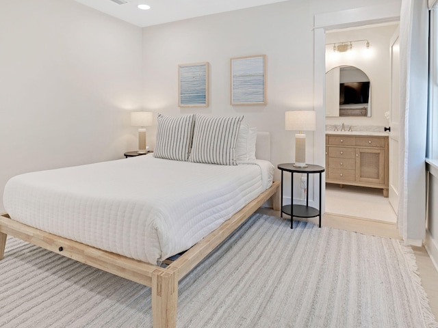 bedroom with sink and light hardwood / wood-style flooring